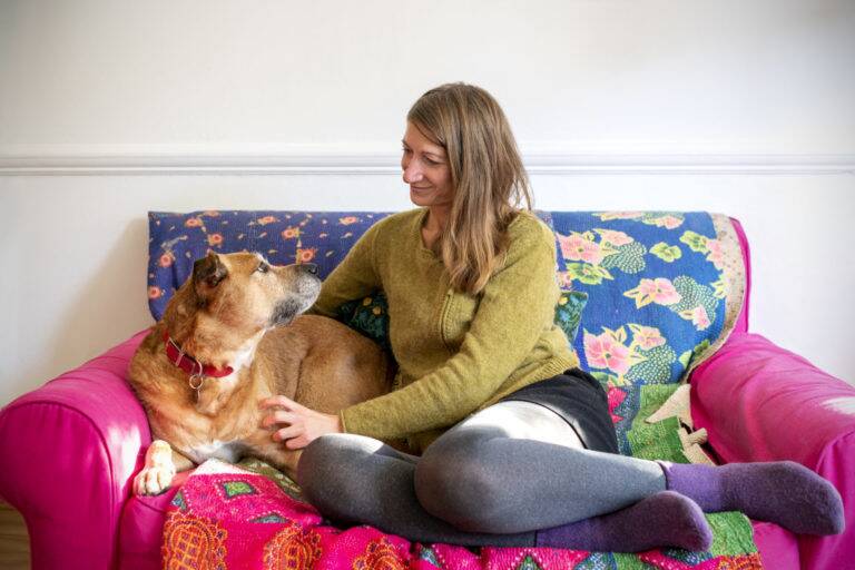 Woman and dog sitting on sofa together