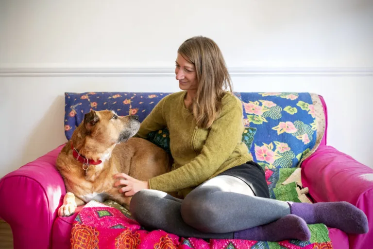 Woman and dog sitting on sofa together