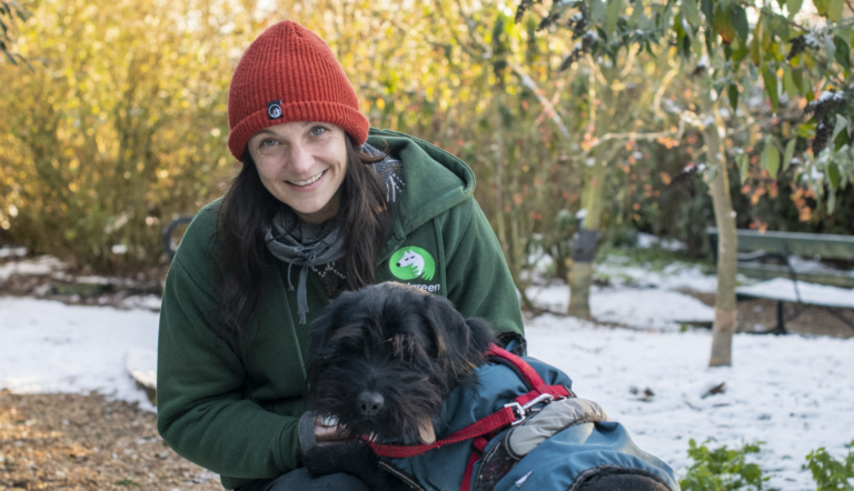 Woman with red hat and a dog in the snow