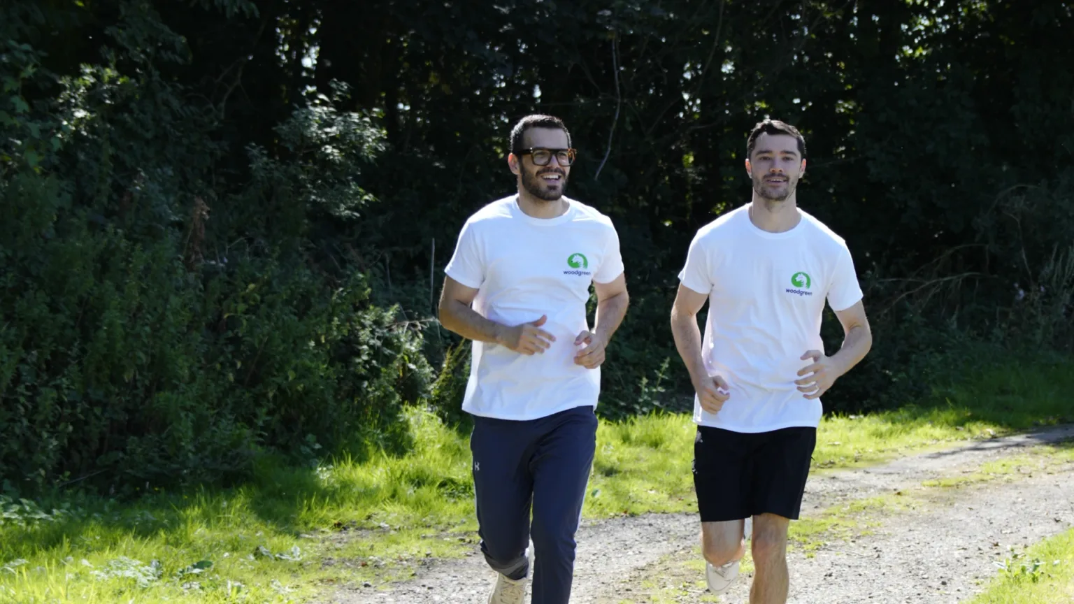 Two people running in Woodgreen t-shirts